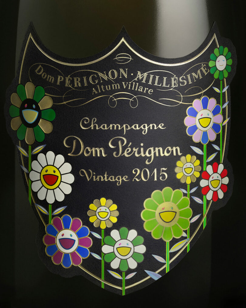 A Takashi Murakami Dom Perignon Vintage 2015 champagne bottle label adorned with colorful, cartoon-style smiling flowers.