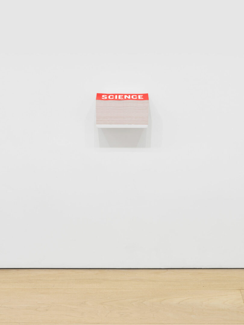 Stack of red bumper stickers on shelf