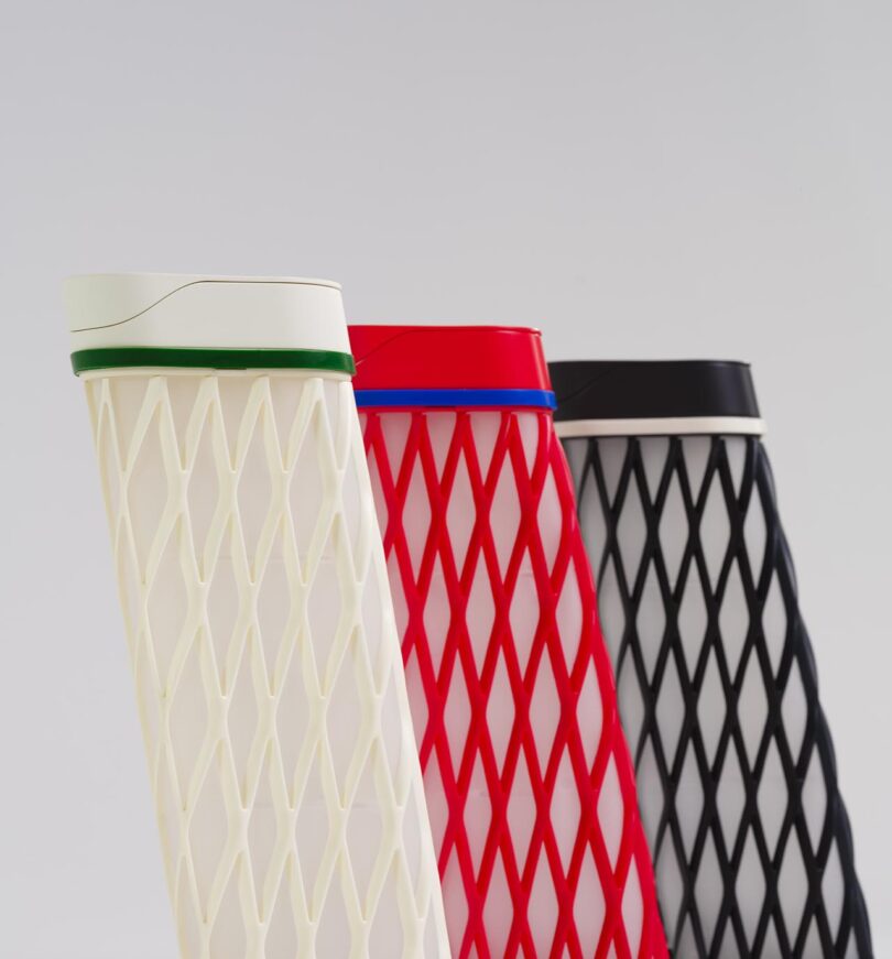 Three patterned tumblers in white, red, and black are displayed upright against a plain light background.