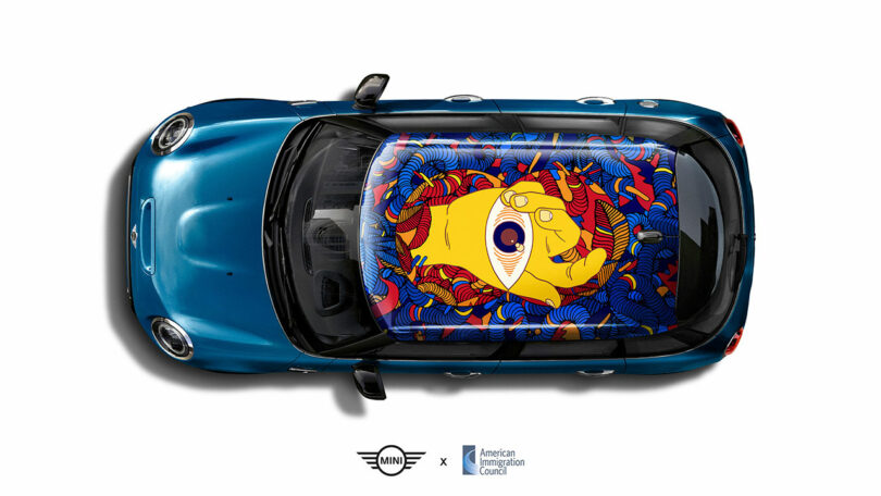 A blue Mini Cooper viewed from above features a vibrant, abstract artwork with a yellow hand holding an eye on its roof. Logos for Mini and American Immigration Council are below the car.