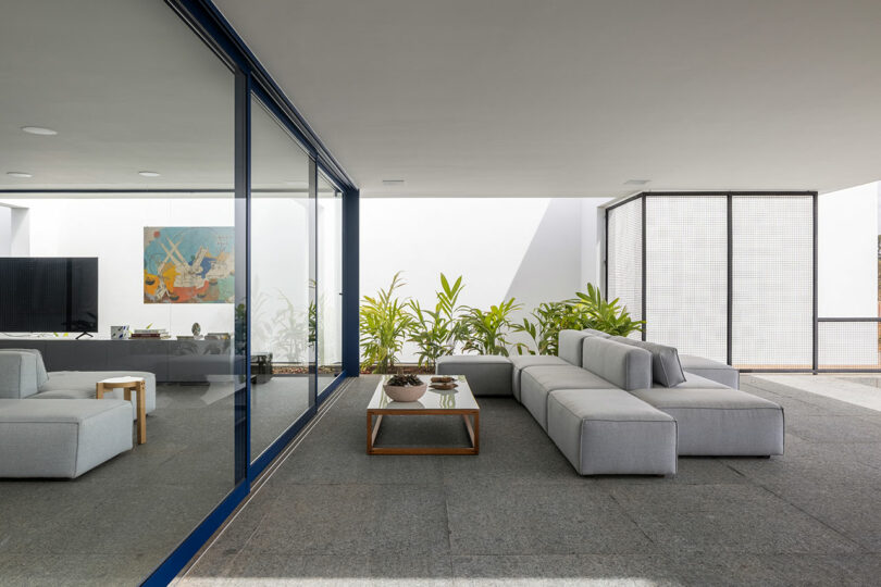 interior view of modern living room with glass walls and two-sided modular sofa