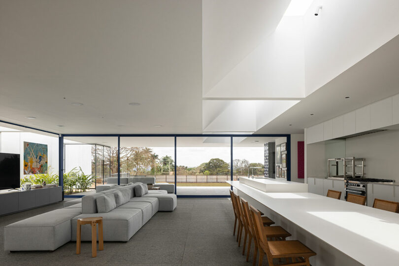 interior view of modern living room with glass walls and two-sided modular sofa
