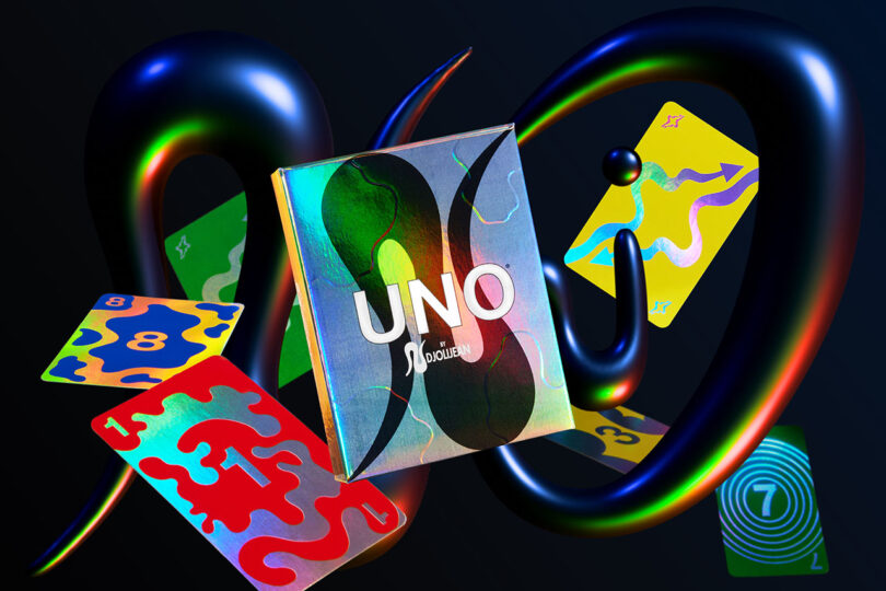A UNO card game box and four colorful abstract UNO cards float with glossy, twisted shapes on a dark background—perfect for the 2025 Gift Guide.