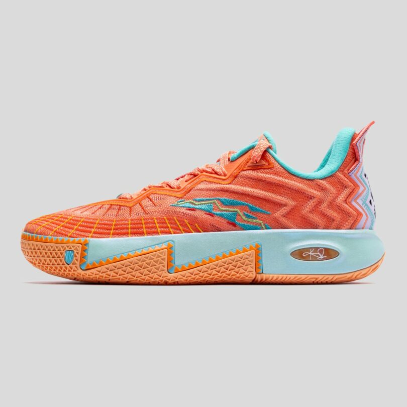 Bright orange athletic sneaker with aqua and blue accents, zigzag patterns, textured sole, and a signature logo on the midsole, shown in a side profile against a gray background