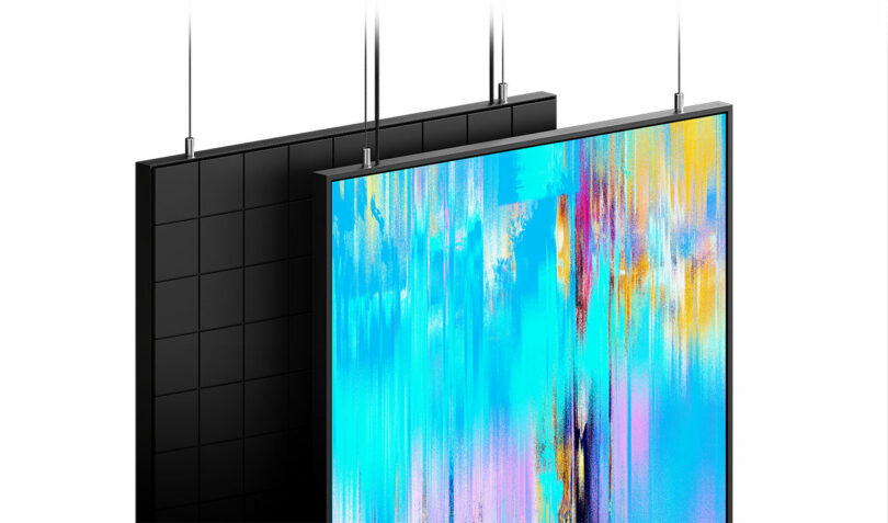 Two rectangular screens are suspended by cables; the front screen displays abstract colorful streaks, while the back screen is black with a grid pattern.