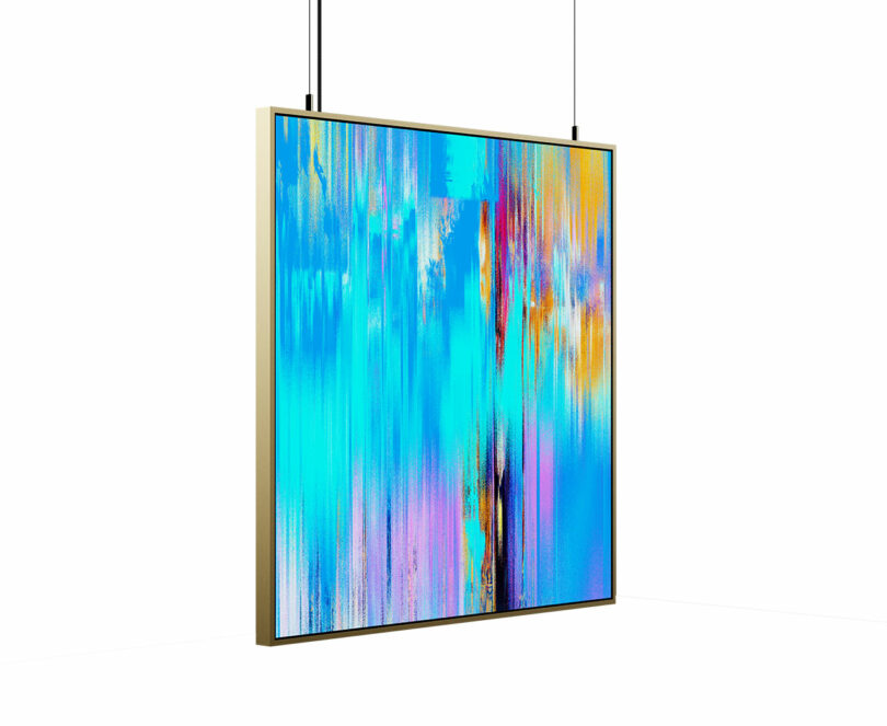 A large, colorful abstract painting with blue, pink, orange, and black vertical streaks, framed in gold and suspended by two cables in a white gallery space.