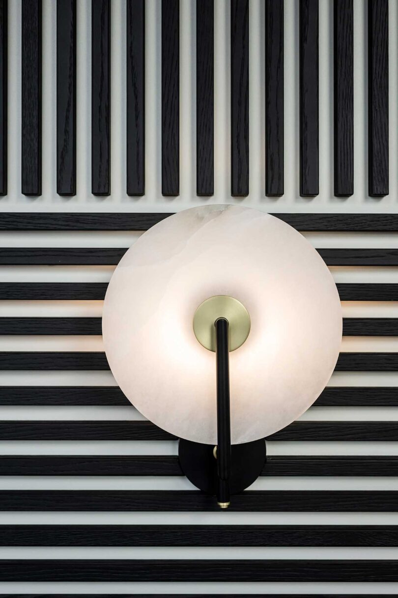 closeup view of modern apartment with feature wall made up of black slats alternating for linear pattern