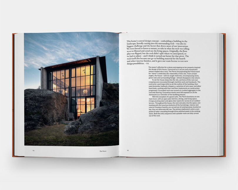 A modern house with large glass windows is built between rock formations, shown at dusk. The opposite page contains a block of descriptive text about the home's design.